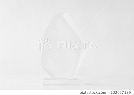 The shot of the blank transparent glass award trophy on a white background, the custom laser cut of the transparent crystal prize. The shot of the blank transparent glass award trophy on a white background, the custom laser cut of the transparent crystal prize. 132627129