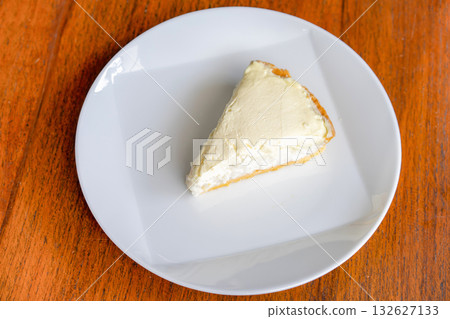 Clear Coconut Cream Pie in the dish on the wood table without anything topping on it. Shooting in the sunlight. 132627133
