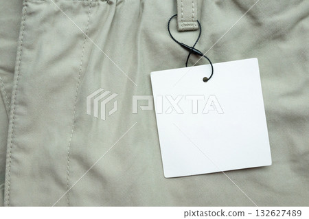 Blank white clothes tag label on gray fabric texture background 132627489