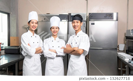 A chef in a cook's coat in the kitchen of a cake shop 132627718