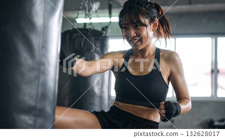 自由搏擊:一位微笑的日本女子和一位男教練正在練習拳擊手套。 自由搏擊:一位微笑的日本女子和一位男教練正在練習拳擊手套。 132628017