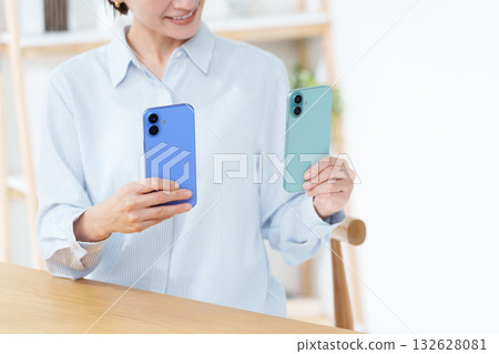 A woman with multiple smartphones 132628081