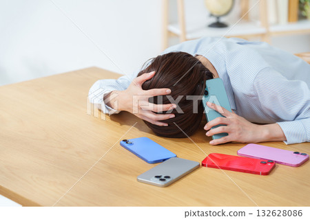 A busy woman with multiple smartphones 132628086