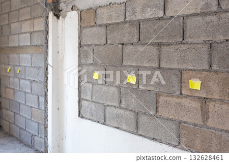 Worker is marking lebel for electrical outlets and wall switches location on new kitchen wall. Worker is marking lebel for electrical outlets and wall switches location on new kitchen wall. 132628461