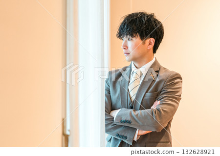 身穿西裝或燕尾服的新郎在婚禮場地的新娘房裡做準備 身穿西裝或燕尾服的新郎在婚禮場地的新娘房裡做準備 132628921