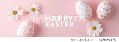 Easter eggs with golden decorations on pink marble background, surrounded by leaves Easter eggs with golden decorations on pink marble background, surrounded by leaves 132629470