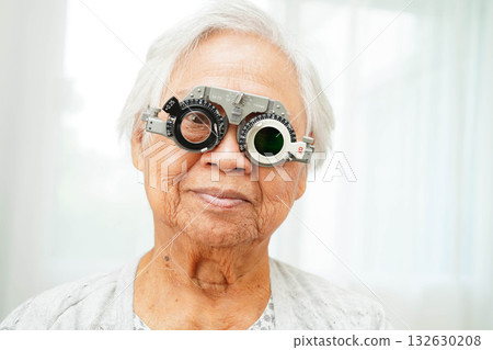 Asian senior woman wearing ophthalmic vision eye test and using optical trial frame. Asian senior woman wearing ophthalmic vision eye test and using optical trial frame. 132630208