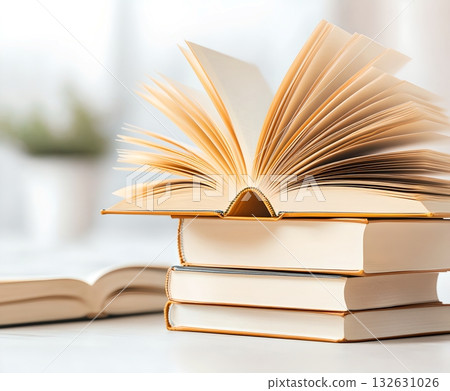 A neatly arranged stack of hardcover books with vibrant multicolored spines sitting on a wooden desk or table symbolizing education knowledge and the joy of reading 132631026