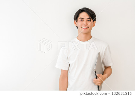 一位身穿 T 卹、手持筆記型電腦的亞洲年輕男子(自由工作者、創作者、程式設計師) 一位身穿 T 卹、手持筆記型電腦的亞洲年輕男子(自由工作者、創作者、程式設計師) 132631515