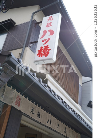 京都一家傳統日式點心店的外觀:歷史悠久的木製建築和暖簾。 京都一家傳統日式點心店的外觀:歷史悠久的木製建築和暖簾。 132632632