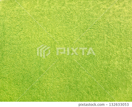 Terry towel or carpet of green color. Background with fluffy towel terry cloth. Natural cotton fabric texture. Long pile canvas. Close-up of soft cotton terry cloth. Material of domestic cotton rug 132633053