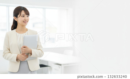 Business scene: portrait of a young, beautiful female office worker with a laptop Business scene: portrait of a young, beautiful female office worker with a laptop 132633240