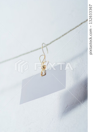 兩張白色卡片用夾子夾在一起。 兩張白色卡片用夾子夾在一起。 132633367