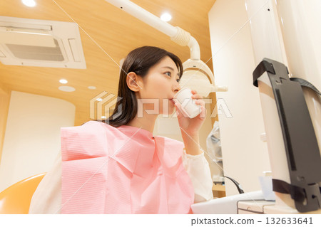 A woman rinsing her mouth after dental surgery 132633641