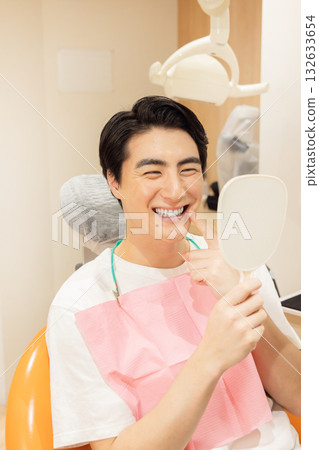 A man checking his teeth at a dental clinic 132633654