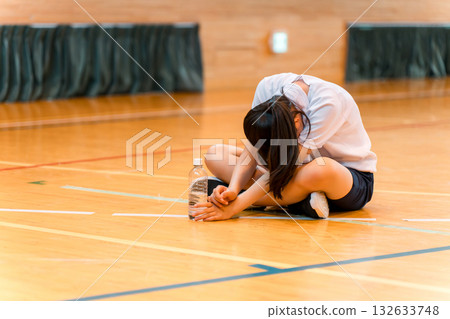 小學、國中和高中女生穿著運動服,在體育館裡努力訓練,疲憊不堪 小學、國中和高中女生穿著運動服,在體育館裡努力訓練,疲憊不堪 132633748
