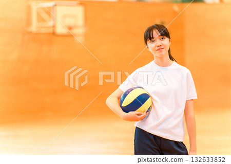 國中和高中女生穿著運動服在體育館打排球 132633852