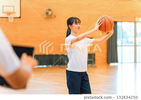 體育館裡,身著運動服、手拿籃球的女國中生和女高中生,以及一名男老師 體育館裡,身著運動服、手拿籃球的女國中生和女高中生,以及一名男老師 132634250