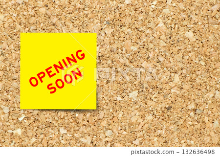 Yellow note paper with word opening soon on cork board background with copy space 132636498