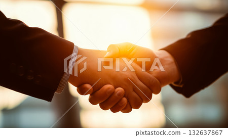 在溫暖的燈光下,握手象徵信任和承諾。 在溫暖的燈光下,握手象徵信任和承諾。 132637867