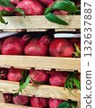 Fresh pomegranates stacked on wooden crates in a vibrant market setting 132637887