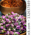 Dried purple rosebuds and saffron displayed in traditional wooden bowls at a local market in the afternoon light 132637889