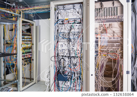 server room rack with tangled network cables creating messy unti 132638864