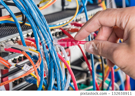 hand of engineer plugging in ethernet cable into server switch p hand of engineer plugging in ethernet cable into server switch p 132638911