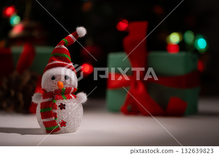 Festive Snowman Figurine Sits Near Wrapped Presents for Christmas Day Festive Snowman Figurine Sits Near Wrapped Presents for Christmas Day 132639823