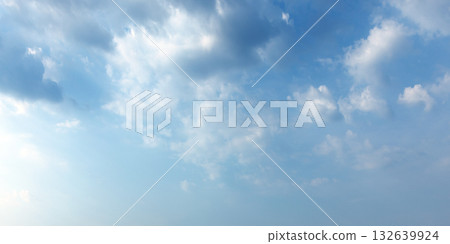 A serene bright blue sky filled with fluffy white clouds A serene bright blue sky filled with fluffy white clouds 132639924