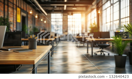 Laptop on a desk in a spacious room with modern furnishings and bright natural light 132640423