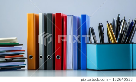 Stack of assorted books in various colors and sizes on a wooden table in natural light 132640533