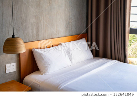 Empty bedroom with clean white linens on wooden bed, cozy hotel room interior. 132641049