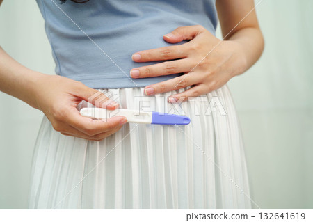 Asian holding pregnancy test for female of ovulation day, fetus, maternity, childbirth, birth control. Asian holding pregnancy test for female of ovulation day, fetus, maternity, childbirth, birth control. 132641619