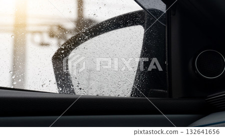 Side mirror view of car with drop of water rain. Background of blurred electric pole under sky with sunlight. 132641656