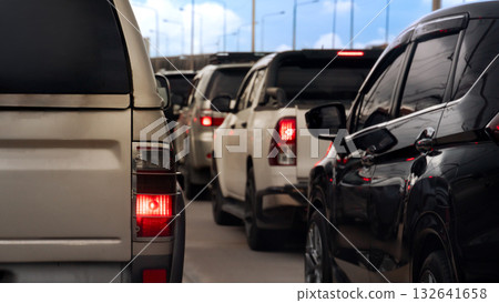 Rear side view of car golden color with turn on brake light. traffic of many car on the road. Cars stuck on the road. Under blue sky and white clouds. 132641658