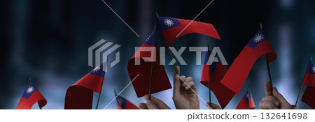 Taiwan flags in their hands on a blurred urban background 132641698