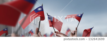Taiwan flags in their hands on a blurred urban background 132641699