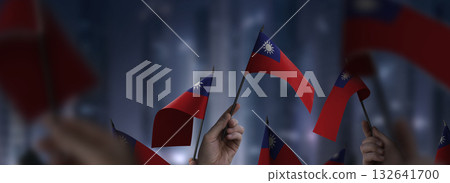 Taiwan flags in their hands on a blurred urban background 132641700