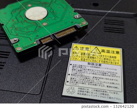 The "Caution: High Temperature" sticker on the bottom of the laptop and the HDD 132642120