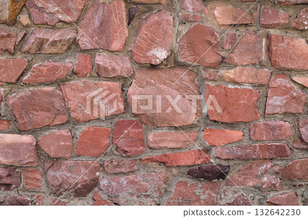 The wall of large raw granite stones of red color, background granite non-uniform The wall of large raw granite stones of red color, background granite non-uniform 132642230