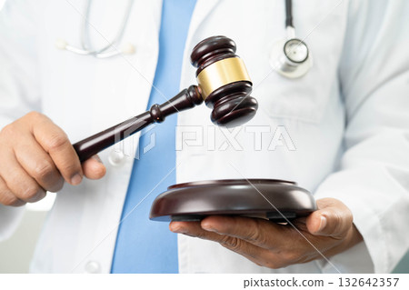 Asian doctor holding court hammer for and crime law justice, forensic medicine. 132642357