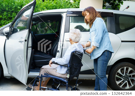 Caregiver help Asian elderly woman disability patient use wheelchair to get in car. 132642364