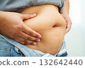 Asian woman use hand to squeeze fat belly big size overweight and obesity. 132642440