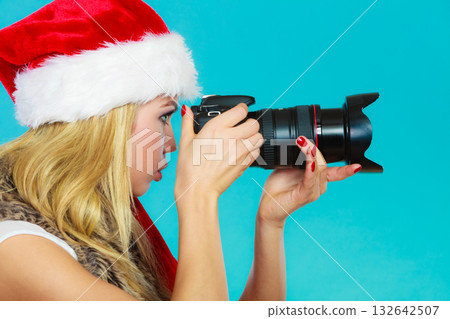 Photographer girl in santa claus hat shooting images Photographer girl in santa claus hat shooting images 132642507