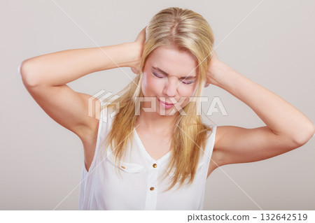 Closeup stressed business woman covers ears with hands Closeup stressed business woman covers ears with hands 132642519