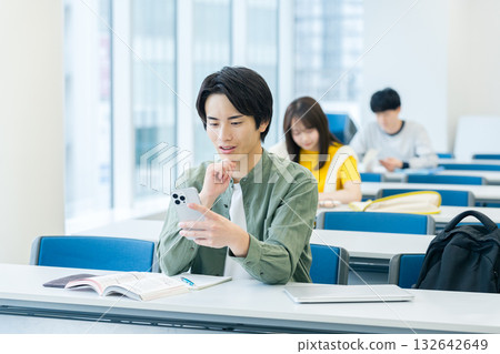 College students looking at smartphones in the classroom College students looking at smartphones in the classroom 132642649