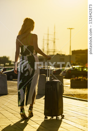 woman with suitcase by sea port 132642873