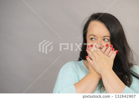 Ashamed woman covering her mouth with hands Ashamed woman covering her mouth with hands 132642907