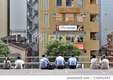 People taking a break on a deck in Akihabara 132642947